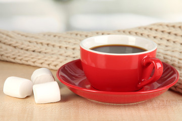 cup of coffee with scarf on table in room