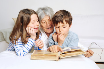 Oma schaut mit Enkelkindern ein Fotoalbum an
