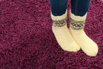 Female legs in colorful socks on color carpet background