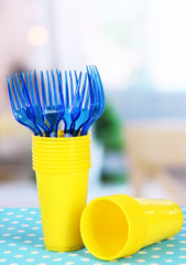 Cups, spoons and forks, of different colors on bright