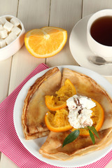 Pancakes with orange on  wooden table