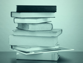 Stack of books in dark green light