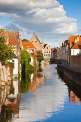 Fototapeta na wymiar Beautiful view of a canal and , bridge, red roofs in Bruges, Bel