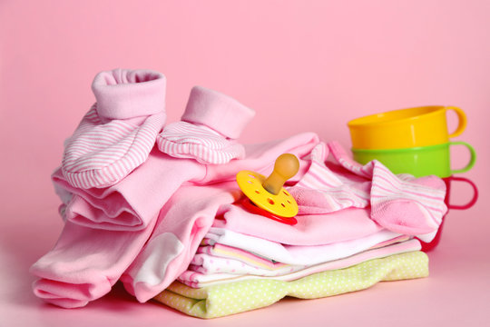 Pile of baby clothes on pink background