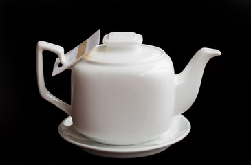 White teapot on a black background