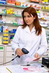 Gorgeous redhead pharmacist working with prescription