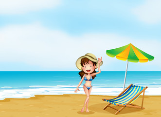 A woman at the beach with an umbrella and a chair