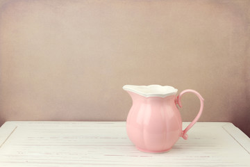 Pink jug on wooden vintage table
