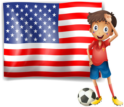A boy with a soccer ball in front of the USA flag