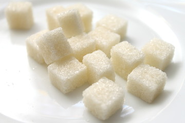 close up of sugar cubes on white plate