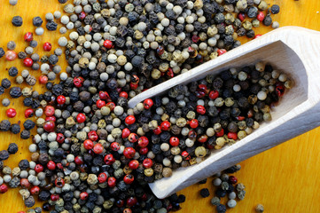 Black, White and pink peppercorns on a wooden scoop