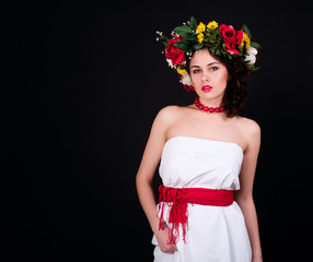 Beautiful woman in flower wreath, white dress and red sash