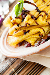 stack of pancakes on a plate and a sprig of basil