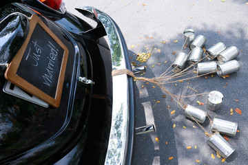 Rear view of a vintage car with just married sign and cans attac
