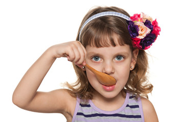 Little girl eats with a spoon