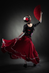 young woman dancing flamenco on black - obrazy, fototapety, plakaty