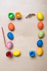 Frame with Easter eggs and paints