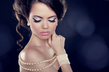 Beautiful woman with a pearl necklace on the bared shoulders