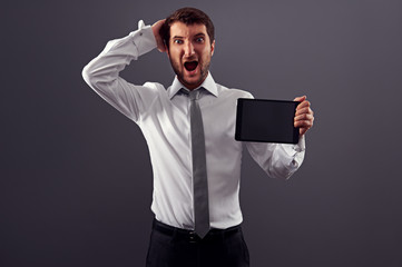 shocked man holding tablet pc and screaming