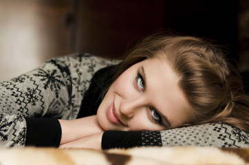 A pretty young woman lying on her arms on couch