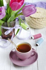 Cup of tea with tulips bouquet