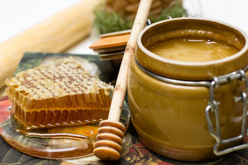 Honey in pot, honeycomb and stick