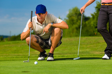 Obraz premium Young sportive couple playing golf on a course
