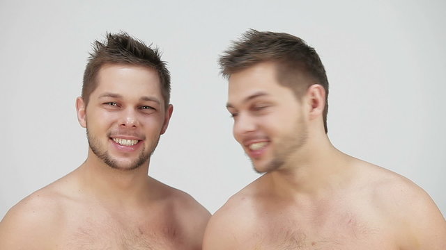 naked twins looking at the camera