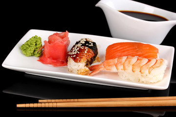 delicious sushi served on plate isolated on black