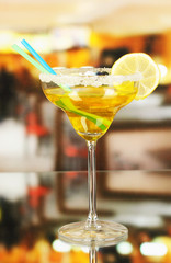 Yellow cocktail in glass on room background