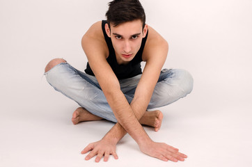 Fototapeta na wymiar Attractive man in ripped jeans and black top stretching.