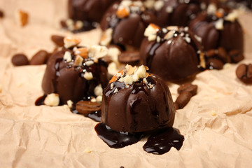 Chocolate candies and coffee beans, on beige paper background