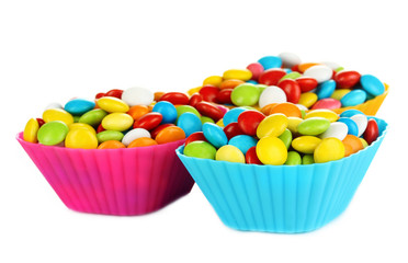 Colorful candies in cupcake cases isolated on white