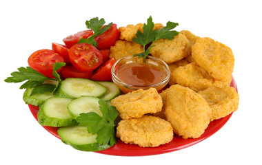Fried chicken nuggets with vegetables and sauce isolated