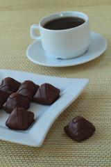 Chocolate candies and cup with coffee