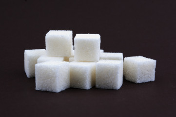 bunch of white lump sugar on a brown background