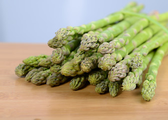 fresh green asparagus sprouts laying on bamboo background