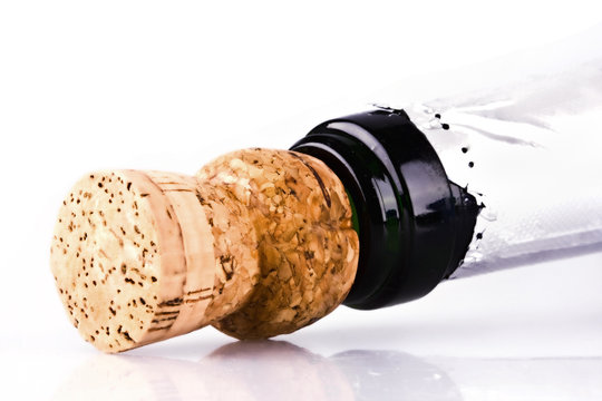 Bottle of champagne with cork over white background