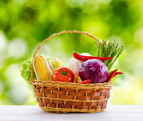 Fresh vegetables in the basket on wooden table