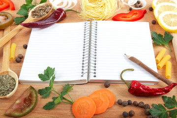 Obraz na płótnie Canvas Notebook dla receptur, warzyw i przypraw na drewnianym stole.