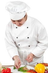 Woman chef puts vegetables on a plate