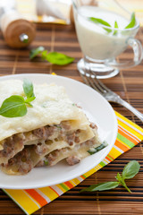 Meat lasagna with grated mozzarella and basil