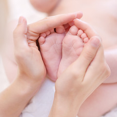 Obraz na płótnie Canvas Baby feet cupped w rękach matki