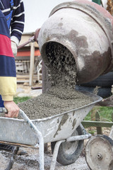 pouring cement into wheelbarrow, from the concrete mixer