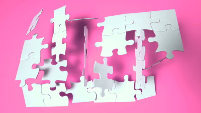 Jigsaw puzzle falling on pink surface