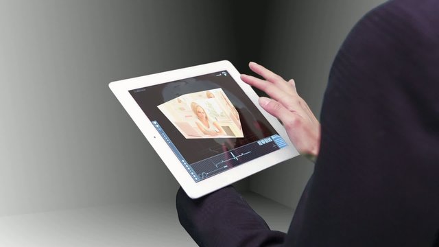 Woman using tablet to view holographic education videos