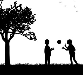 Kids playing with ball in park in spring silhouette