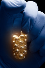 Obraz premium Hand holding test tube with white pearls