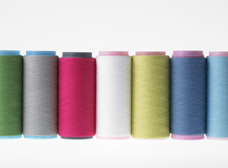 Colors, colorful spools of thread on a white background