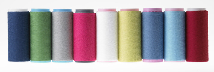 Colors, colorful spools of thread on a white background